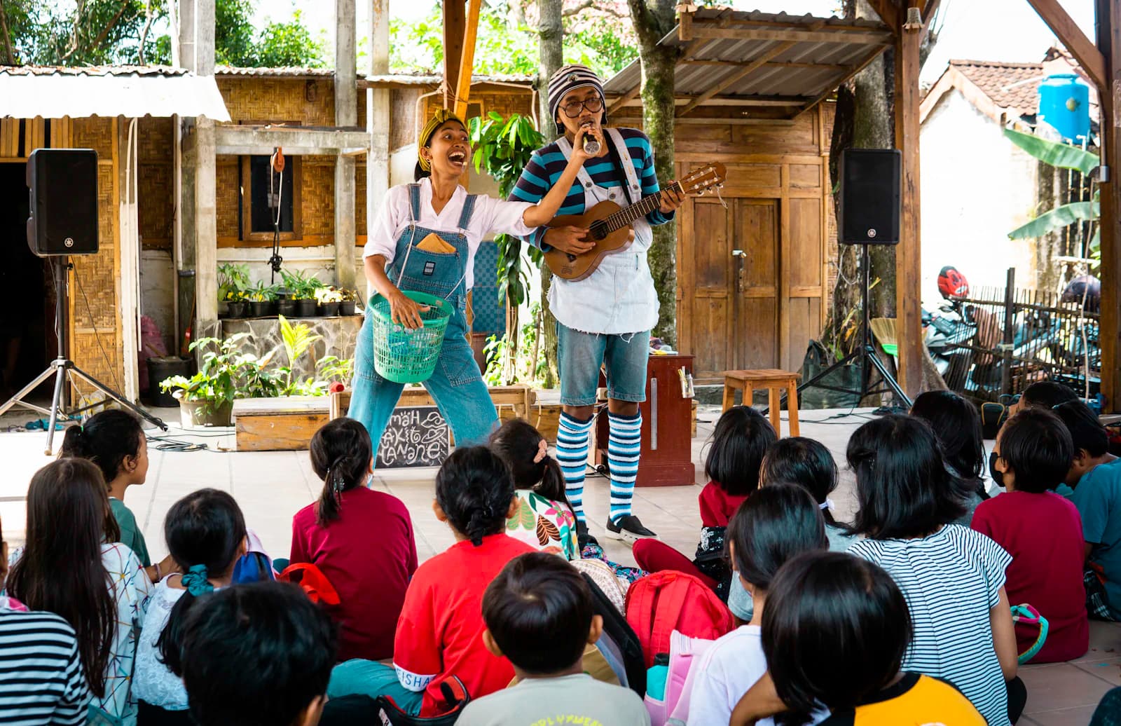 Children watching two musicians perform with a ukulele