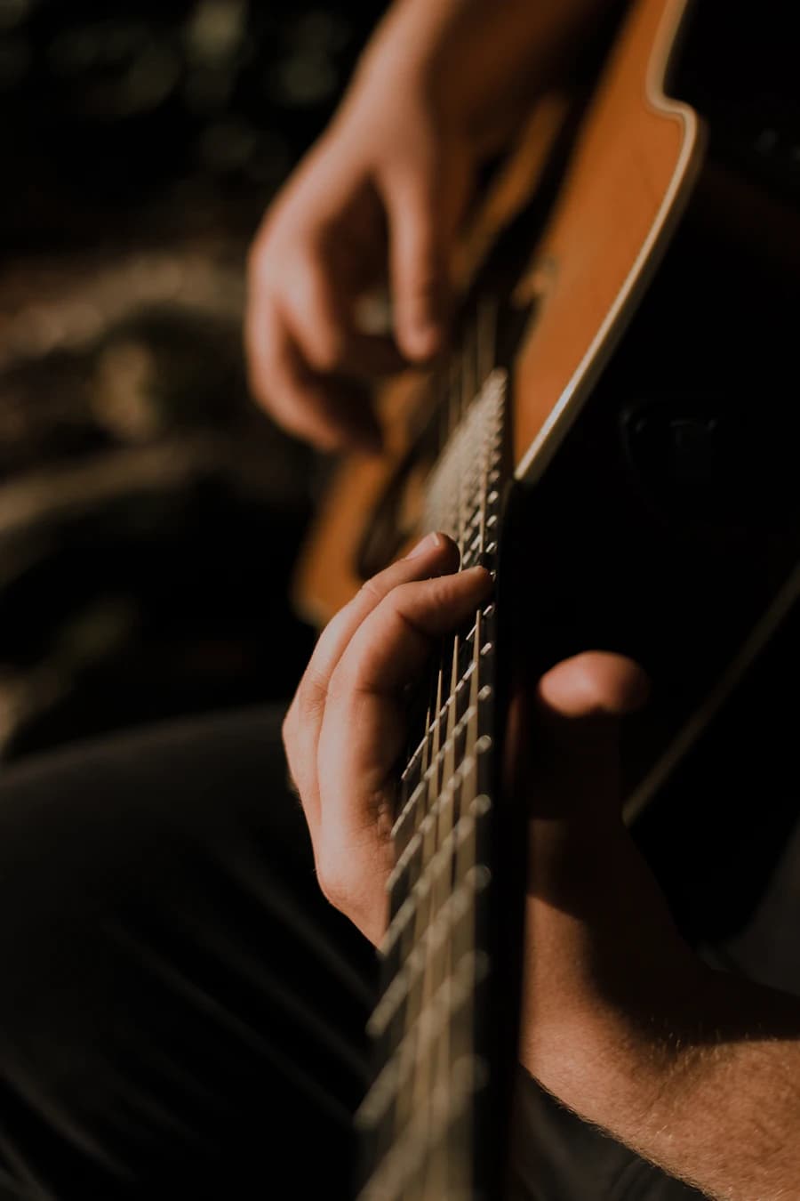 Close-up of hands strumming an acoustic guitar