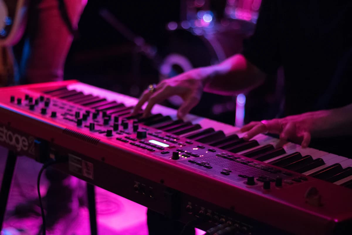 Student playing an electronic keyboard under coloured lights